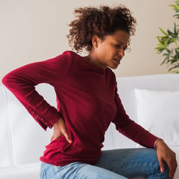 A new mother holding her lower back in pain