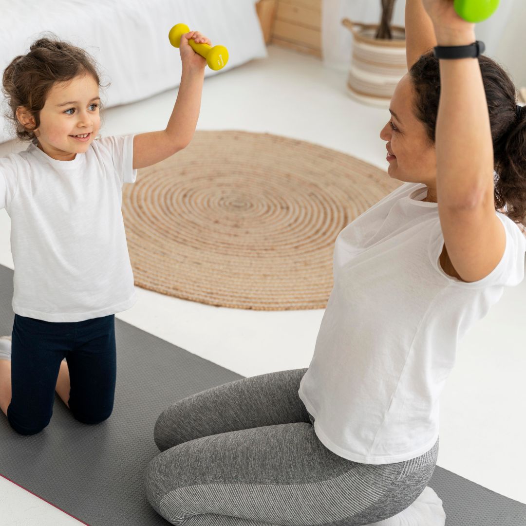 Image of Mother and daughter exercising at home with dumbbells