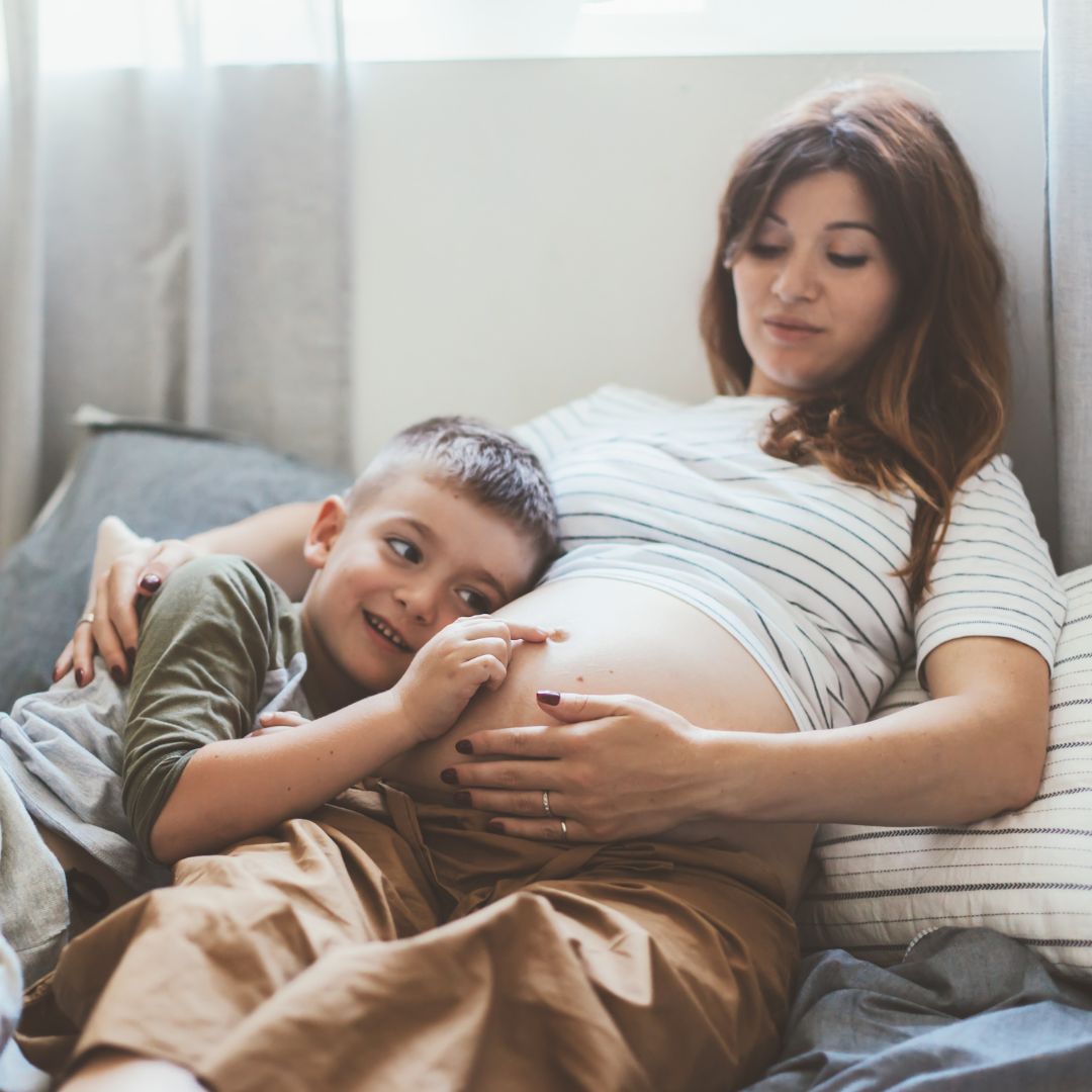 young boy cuddling his mom's pregnant belly